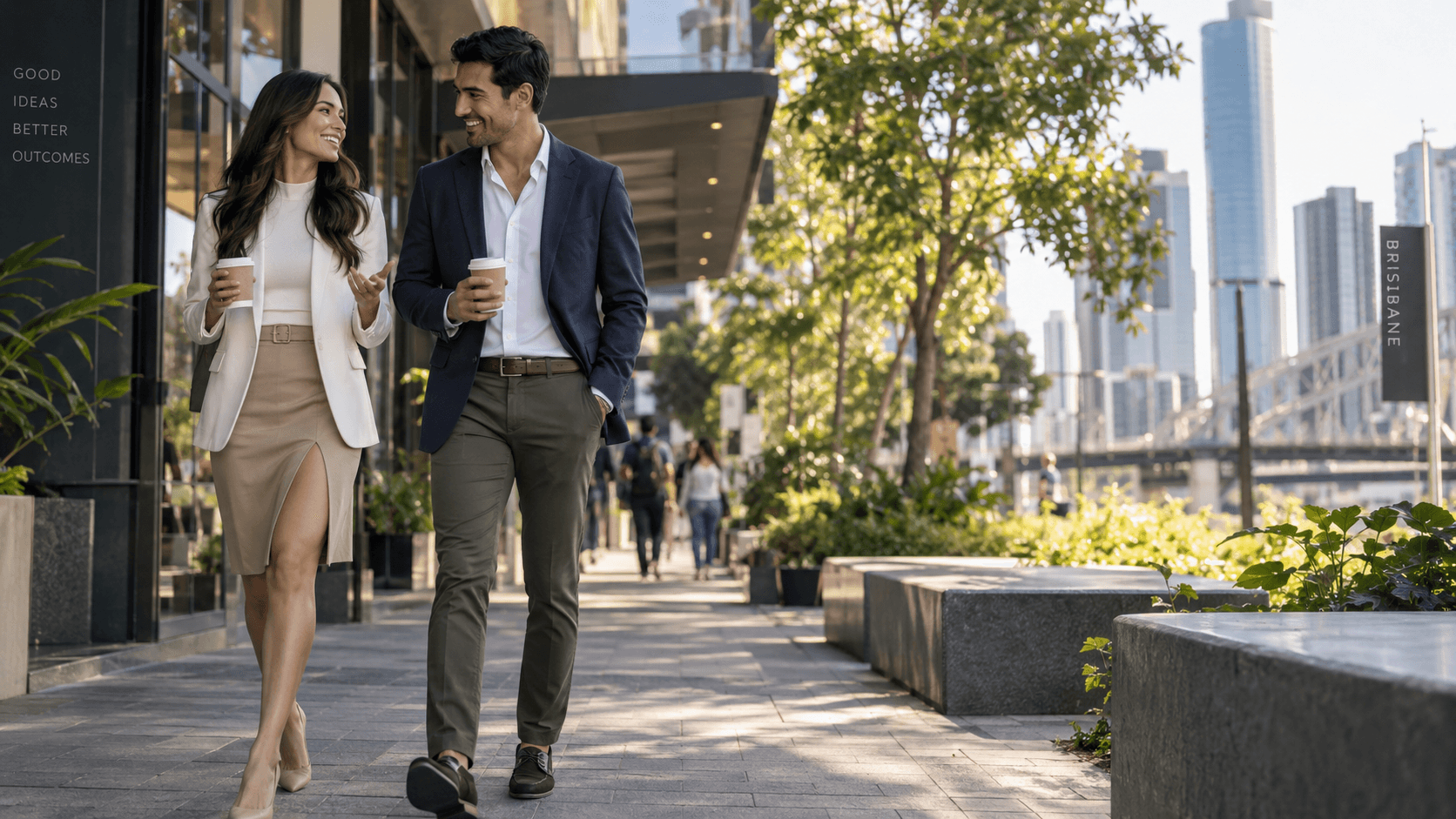 Two business leaders walking together with the Brisbane skyline beyond.